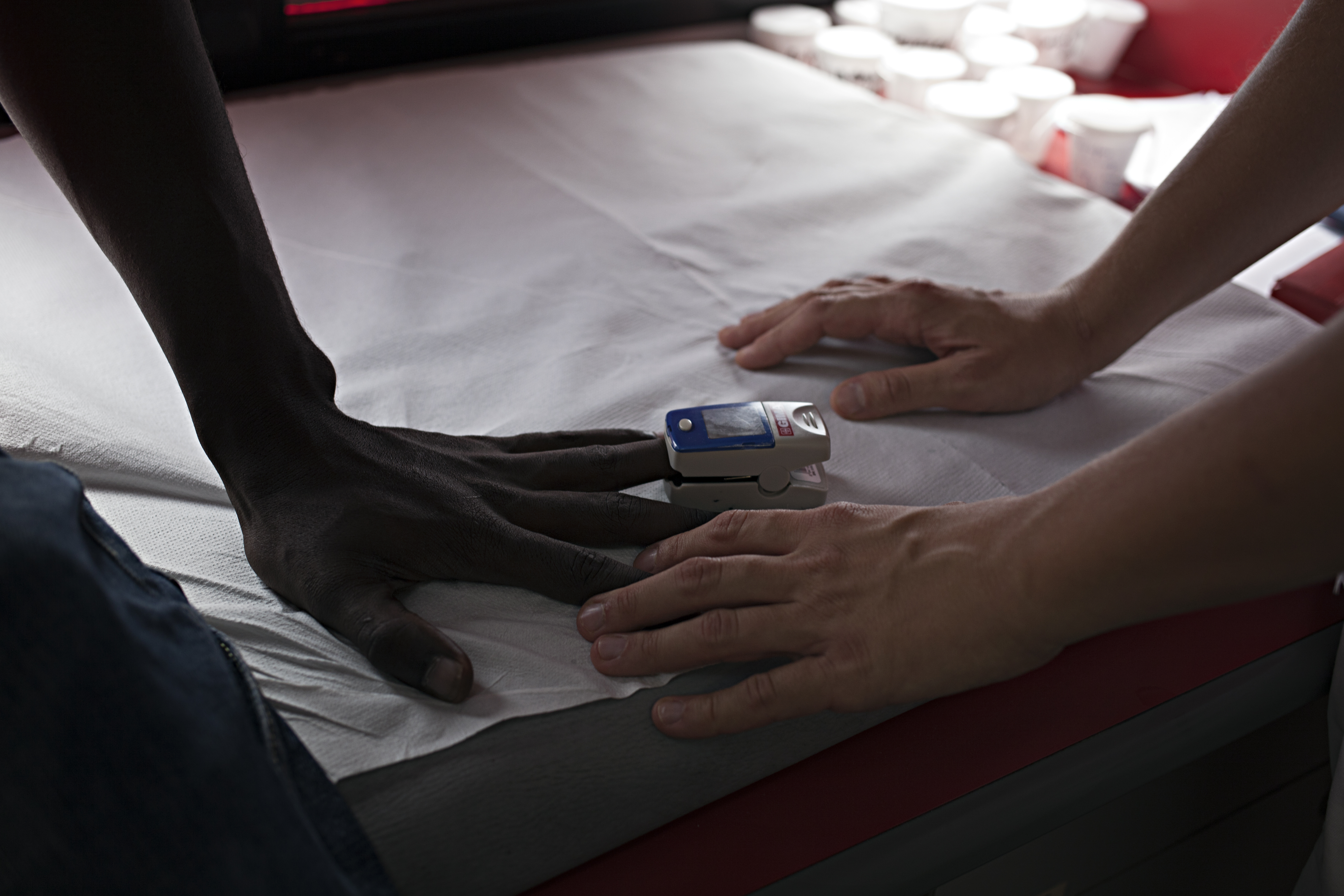 The hand of a patient and that of a member of EMERGENCY staff